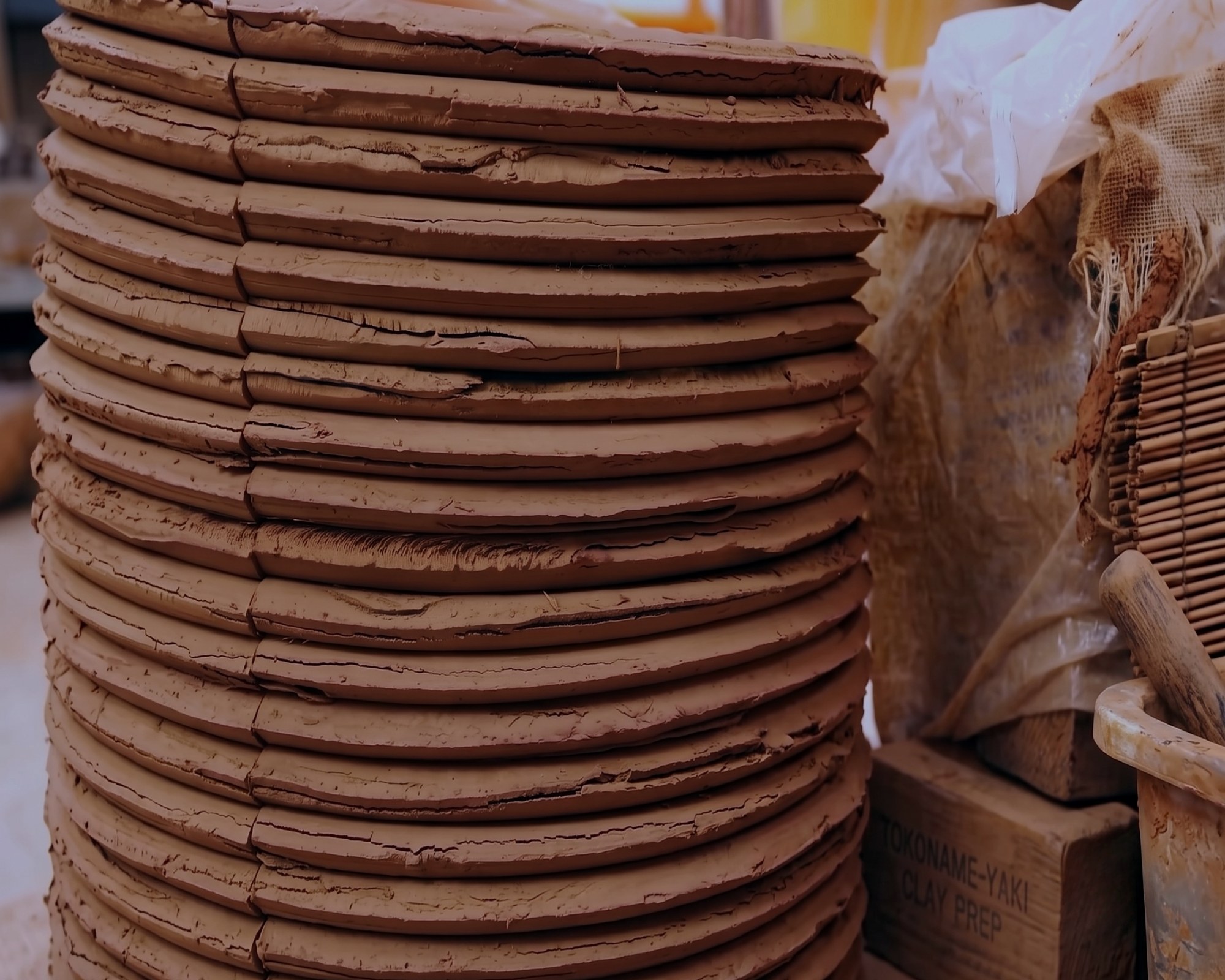 Stacked discs of iron-rich clay, wedged and left to rest before throwing — 土づくり